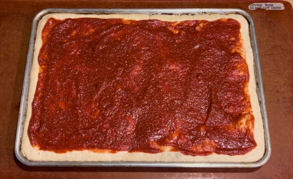 A sauced deep dish pizza before adding cheese.