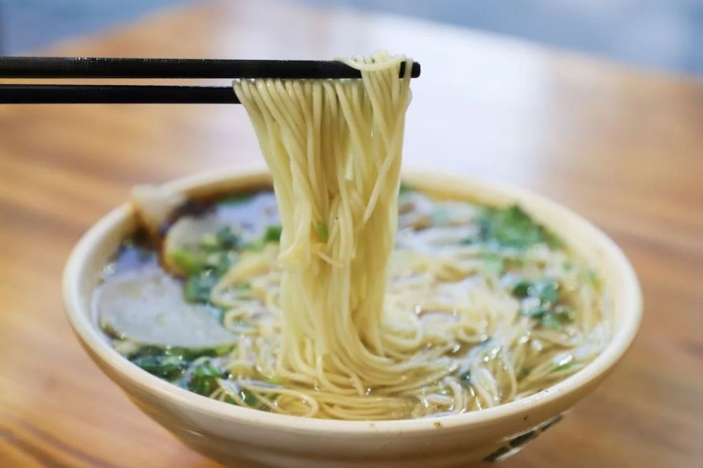 A photo showing a bowl of ramen with vegetable broth.